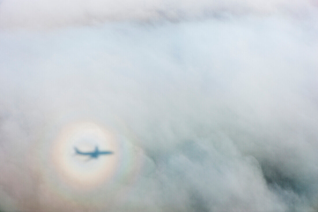 The shadow of an airplane cast by a sundog on clouds, Alaska, United States of America