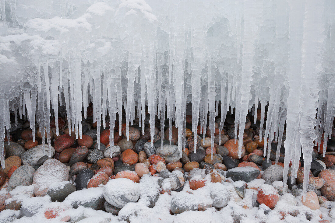 Icicles and snow over pebbles on the shore of Lake Superior