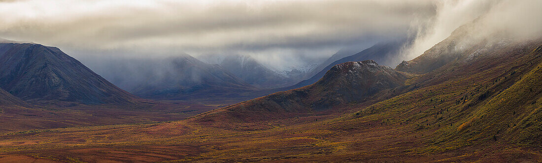 The Blackstone Valley along the Dempster Highway is shrouded in clouds in autumn, Yukon, Canada