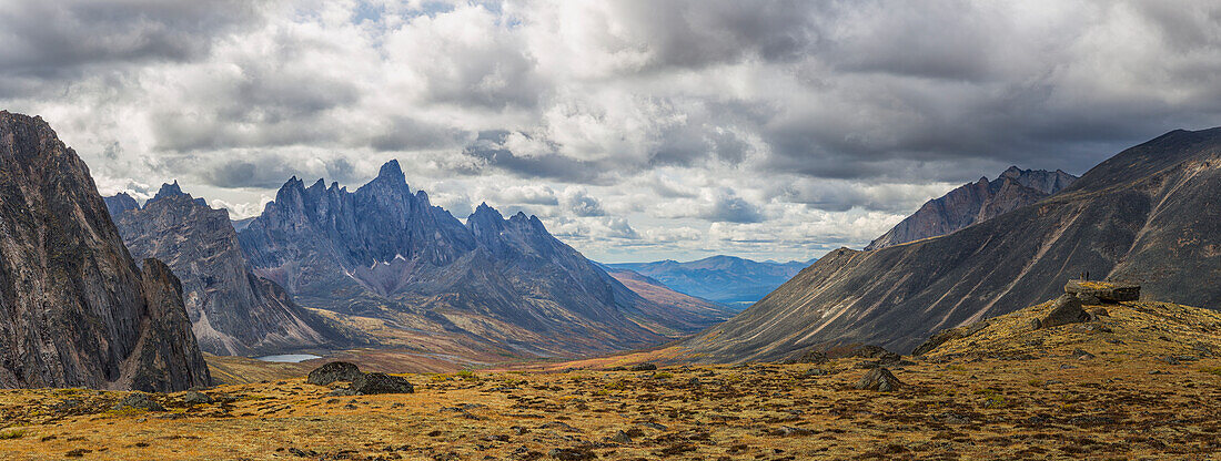 Men standing on a boulder in the distance in Tombstone Territorial Park in autumn, Yukon, Canada