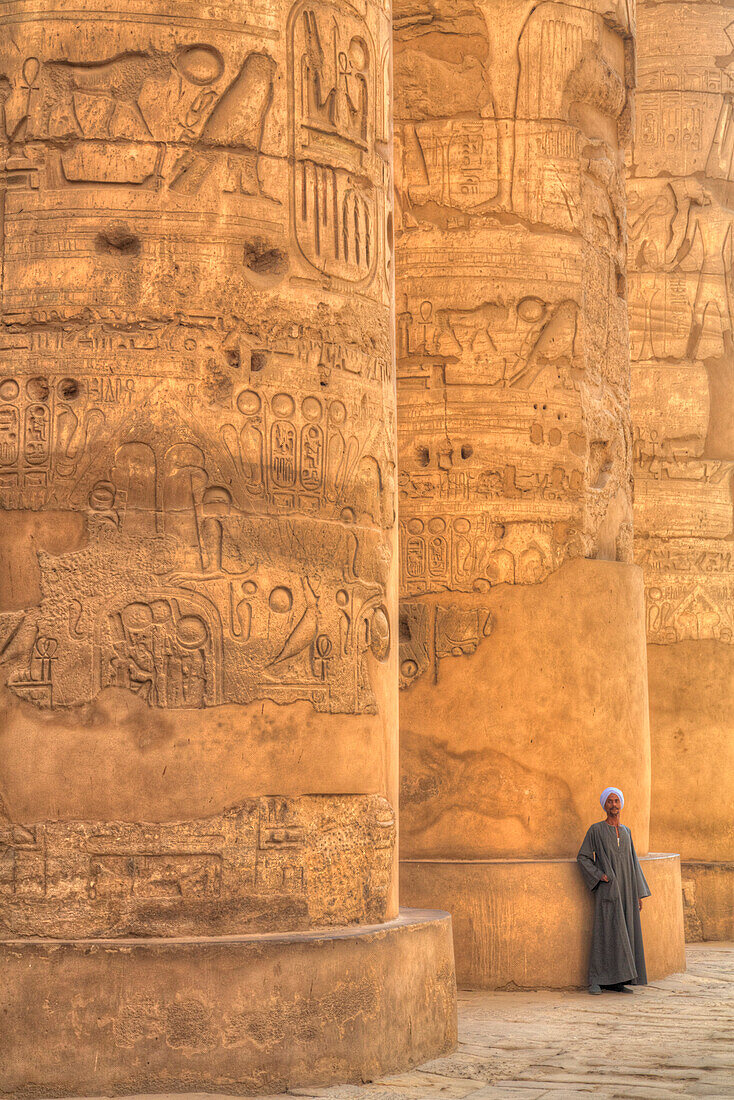 Local man, columns in the Great Hypostyle Hall, Karnak Temple, Luxor, Thebes, UNESCO World Heritage Site, Egypt, North Africa, Africa