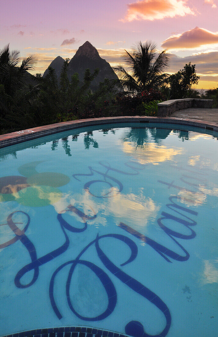 swimming pool of La Haut Plantation hotel at sunset with view to palm trees and volcano mountains The Pitons with Gros and Petit Piton, UNESCO world heritage, Soufriere, St. Lucia, Saint Lucia, Lesser Antilles, West Indies, Windward Islands, Antilles, Car