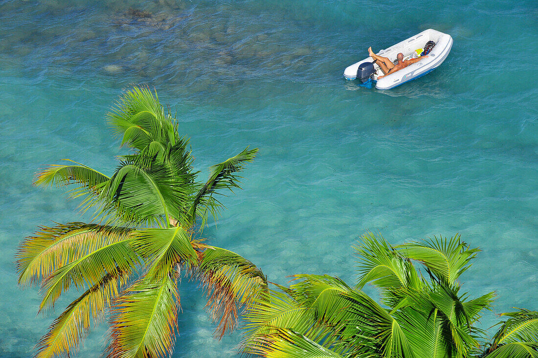Mann in Schlauchboot umgeben von Wellen und Palmen, Meer, Tobago Cays, St. Vincent und die Grenadinen, Saint Vincent and the Grenadines, Kleine Antillen, Westindische Inseln, Windward Islands, Antillen, Karibik, Mittelamerika