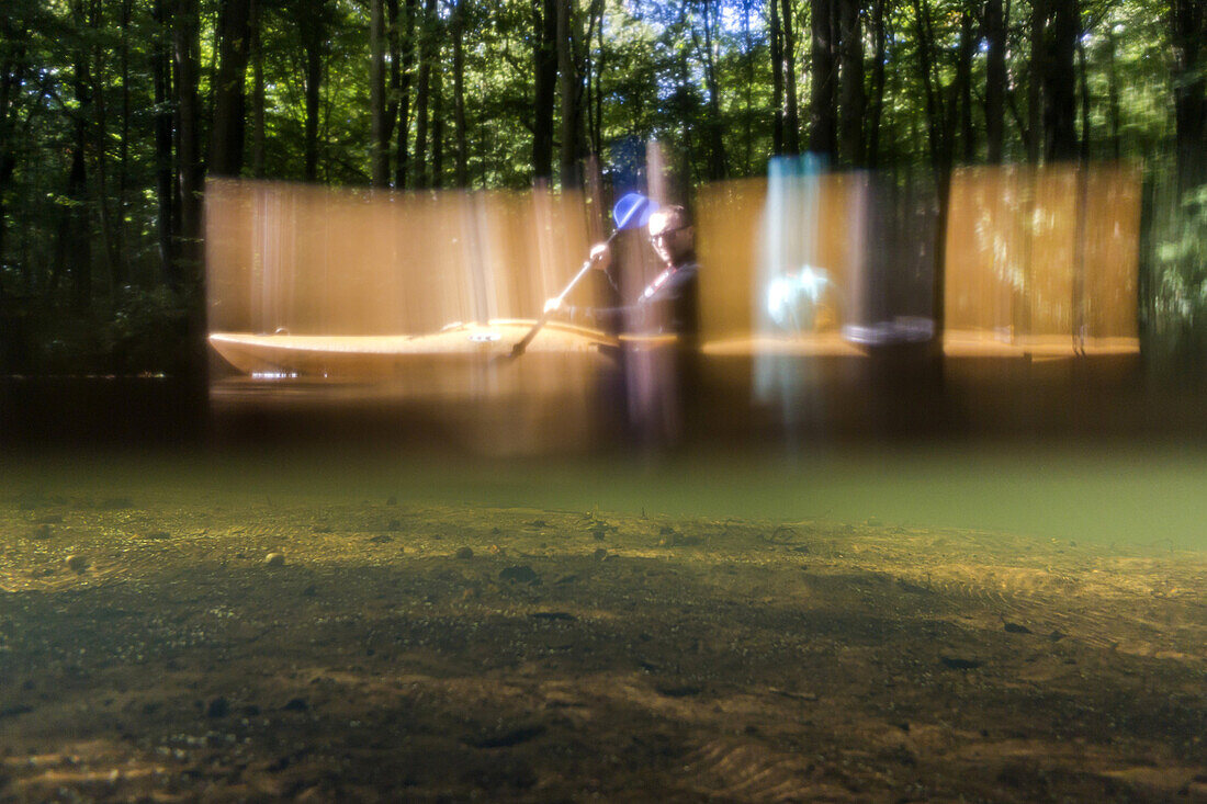 Kajak-Tourist paddeln durch das Biosphärenreservat Spreewald. Aufnahme auf Niveau der Wasseroberflächen. Zur Hälfte über Wasser, zur Hälfte unter Wasser, Biosphärenreservat, Schlepzig, Brandenburg, Deutschland