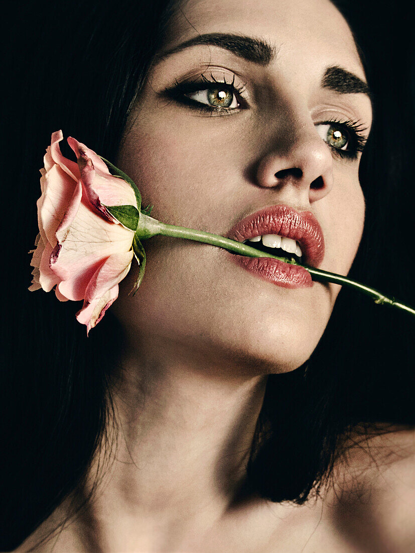 Young Adult Woman Biting Rose Stem
