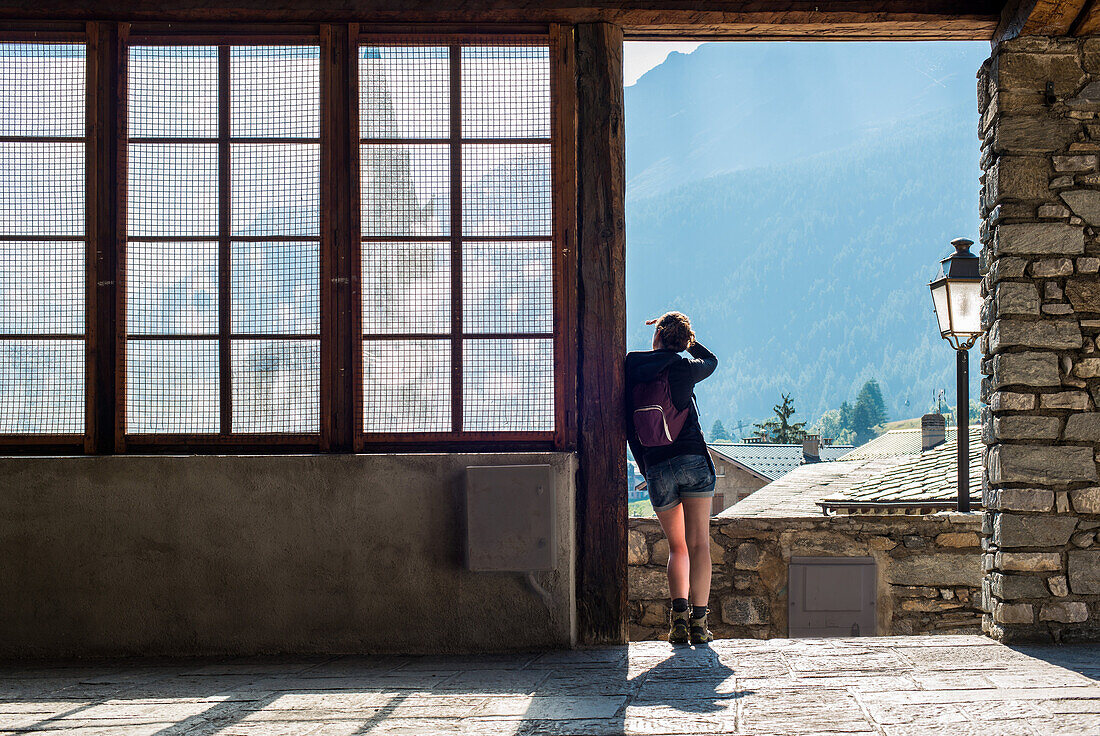 Young Adult Woman Looking at Panoramic View from Village Doorway, Rear View, Lanslevillard, Val Cenis Vanoise, France