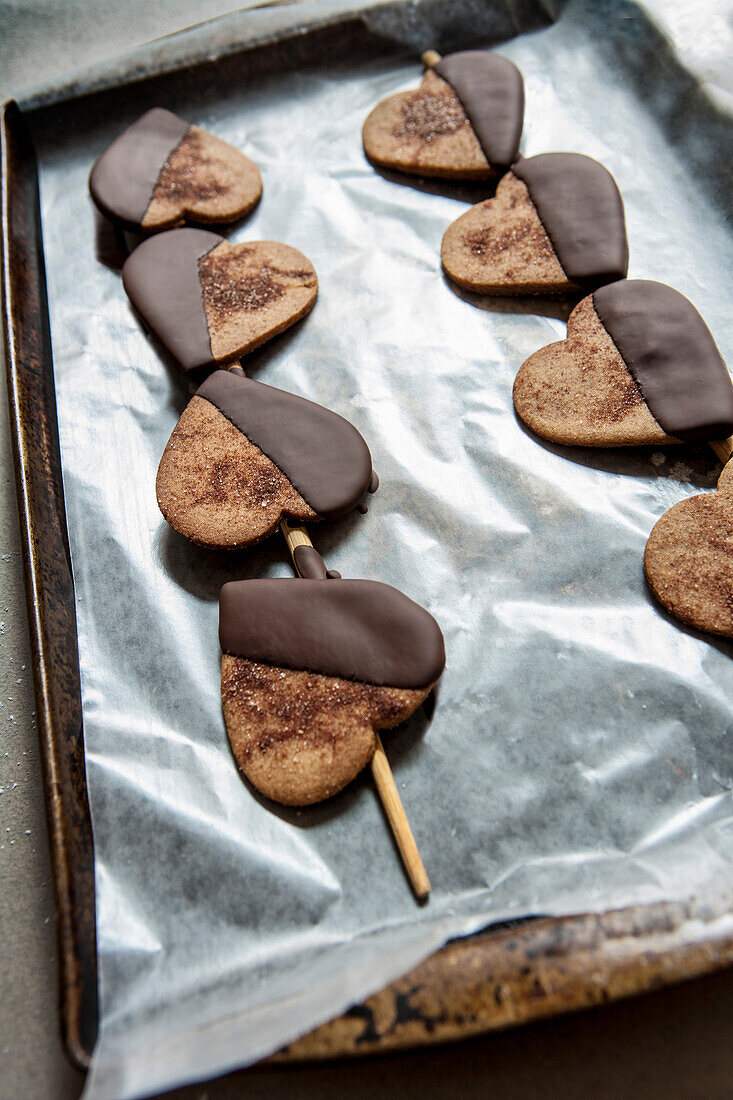 Heart-Shaped Cookies Dipped in Chocolate on Baking Sheet