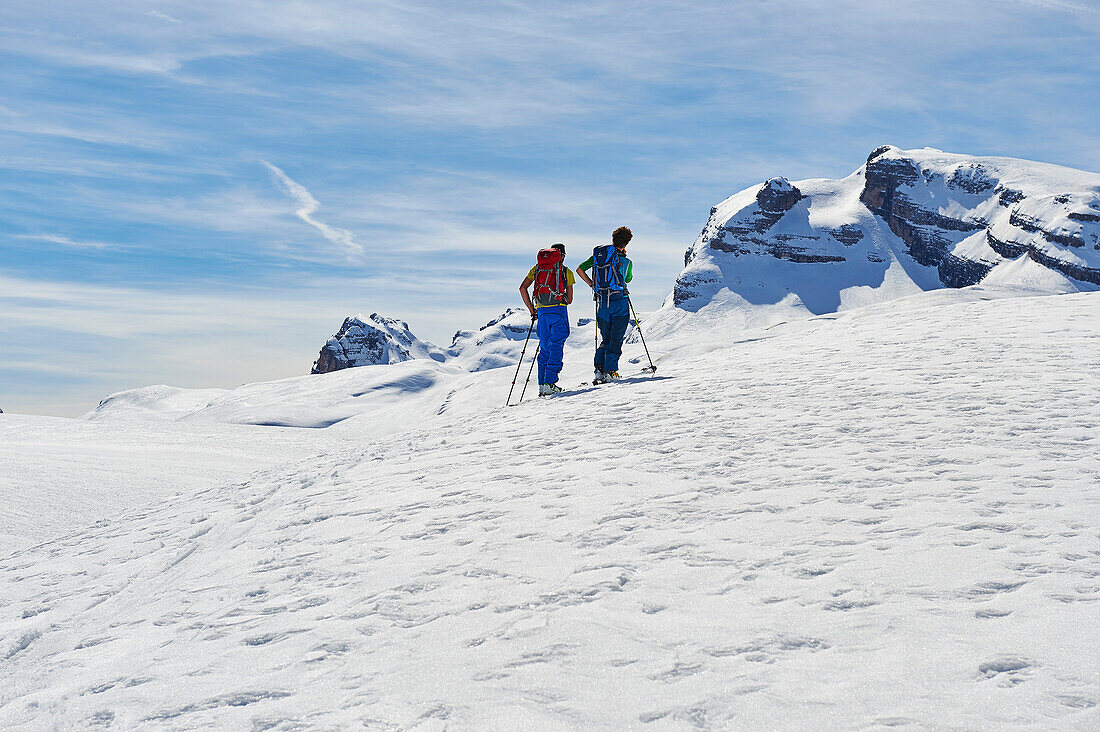 Zwei Männer gehen eine Skitour Ski und schauen auf Cima Grosté, klettern, Skitour, Brenta Gebirge, Dolomiten, Trentino, Italien