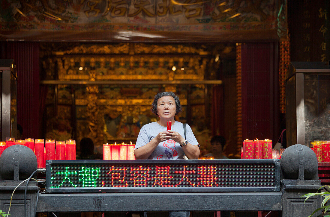 Taiwanese woman is praying in a temple in Taipeh, Taiwan, Republic of China, Asia