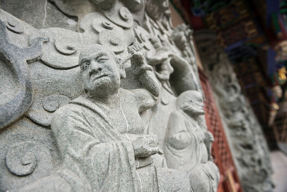 Mönch sticht Dolch ins Ohr - Gravur aus Stein im Kloster Po Lin, Lantau Insel, Hongkong, China, Asien