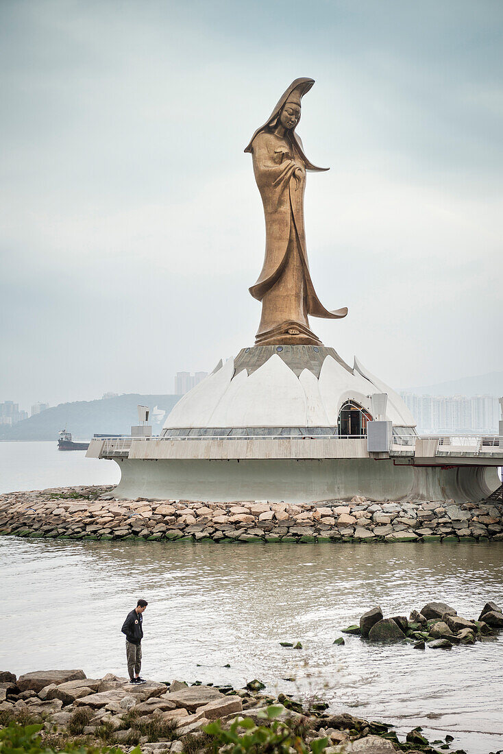 chinesischer Mann steht am Ufer vor Guan Yin Statue, Macau, China, Asien