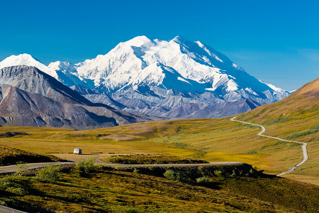 Scenic view of Mt. McKinley, Thorofare Pass, and Stony Dome in the foreground with a vehicle on the park road, Denali National Park, Interior Alaska