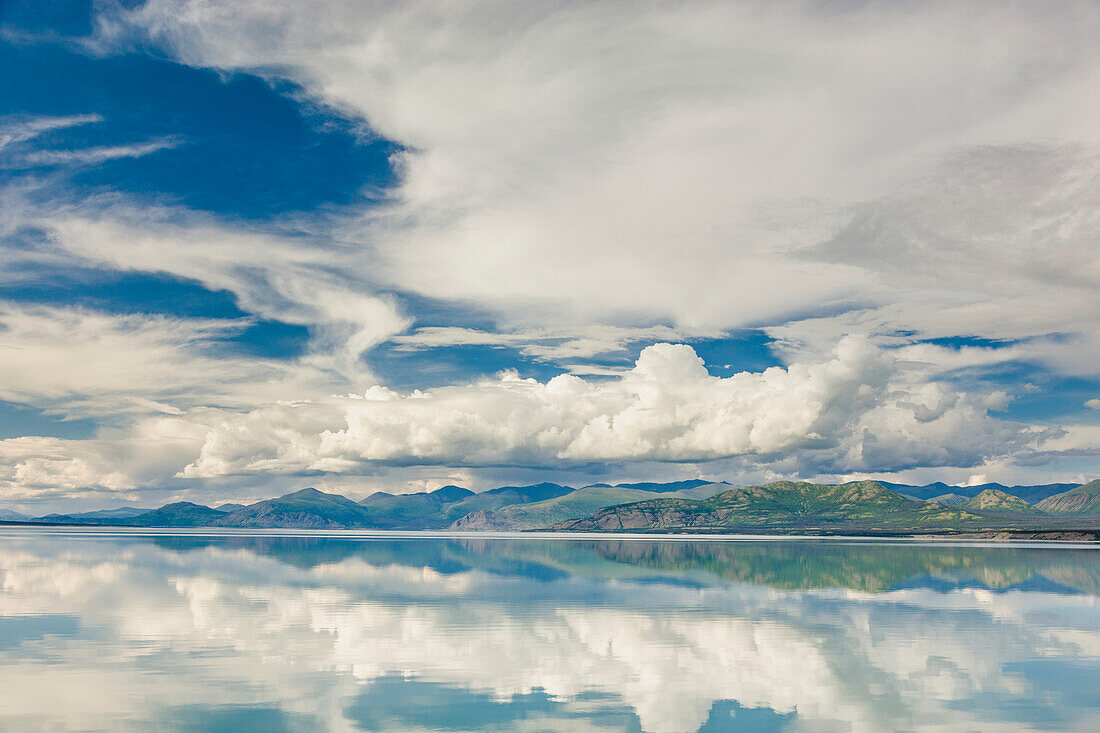 Scenic view of mountains and clouds reflecting in the calm waters of Kluane Lake, Yukon Territory, Canada, Summer