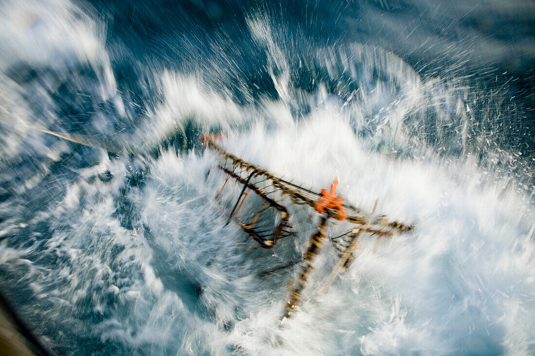 A Baited Pot Crashes Into The Water From Aboard The F/V Centurion In Kachemak Bay, Alaska