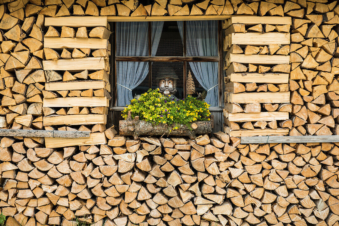mit Brennholz umrahmtes Fenster, bei Mittenwald, Oberbayern, Bayern, Deutschland