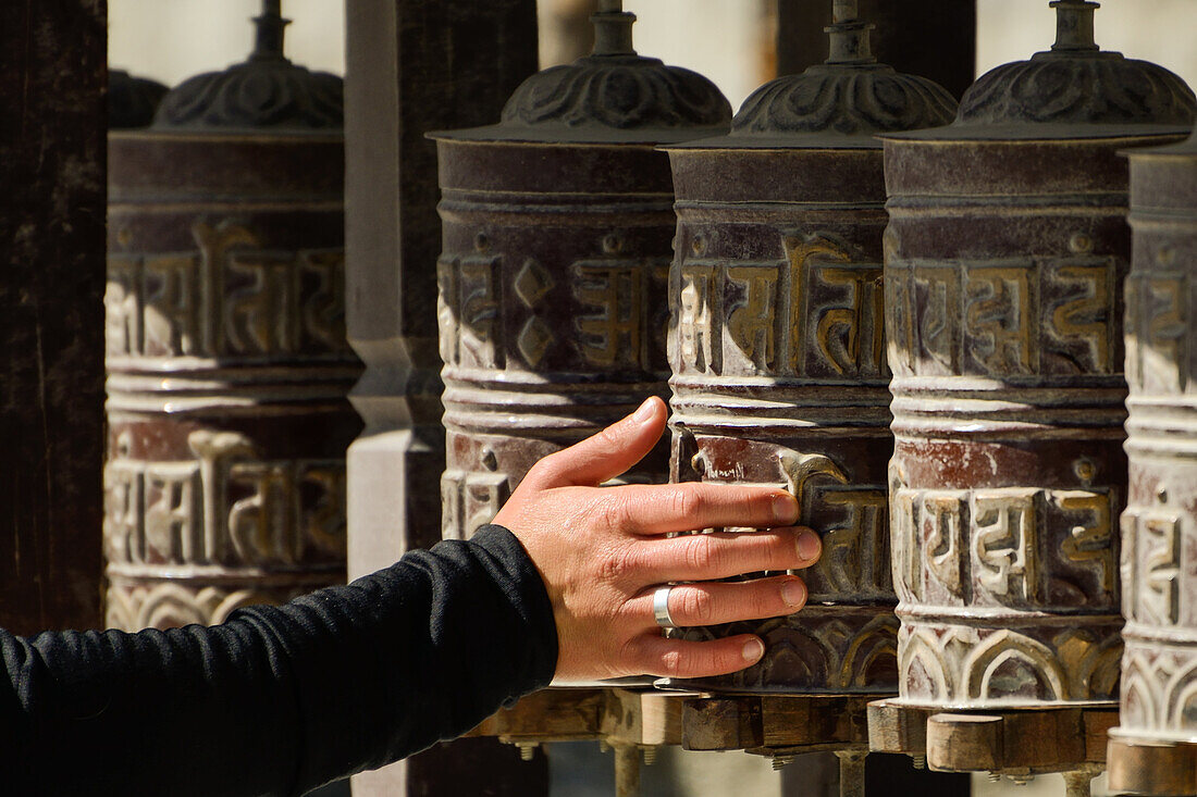 Frau dreht Gebetsmuehlen in Mustang, Nepal, Himalaya, Asien