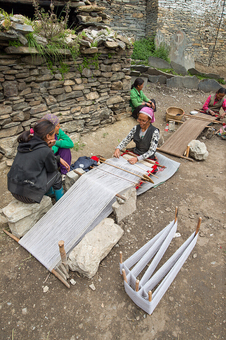 Frauen weben auf eine einfachen Webstuhl am Boden in Nar, Nepal, Himalaya, Asien