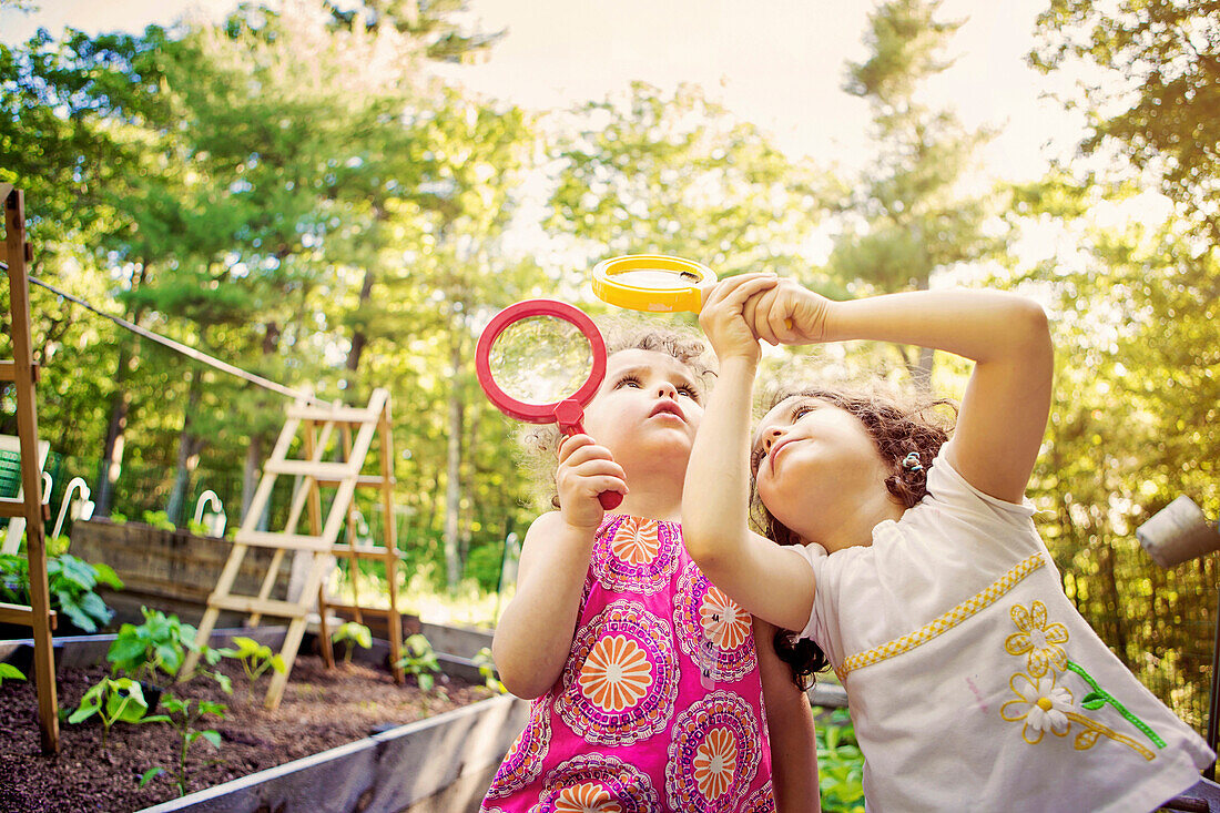 Girls examining caterpillar with magnifying glass