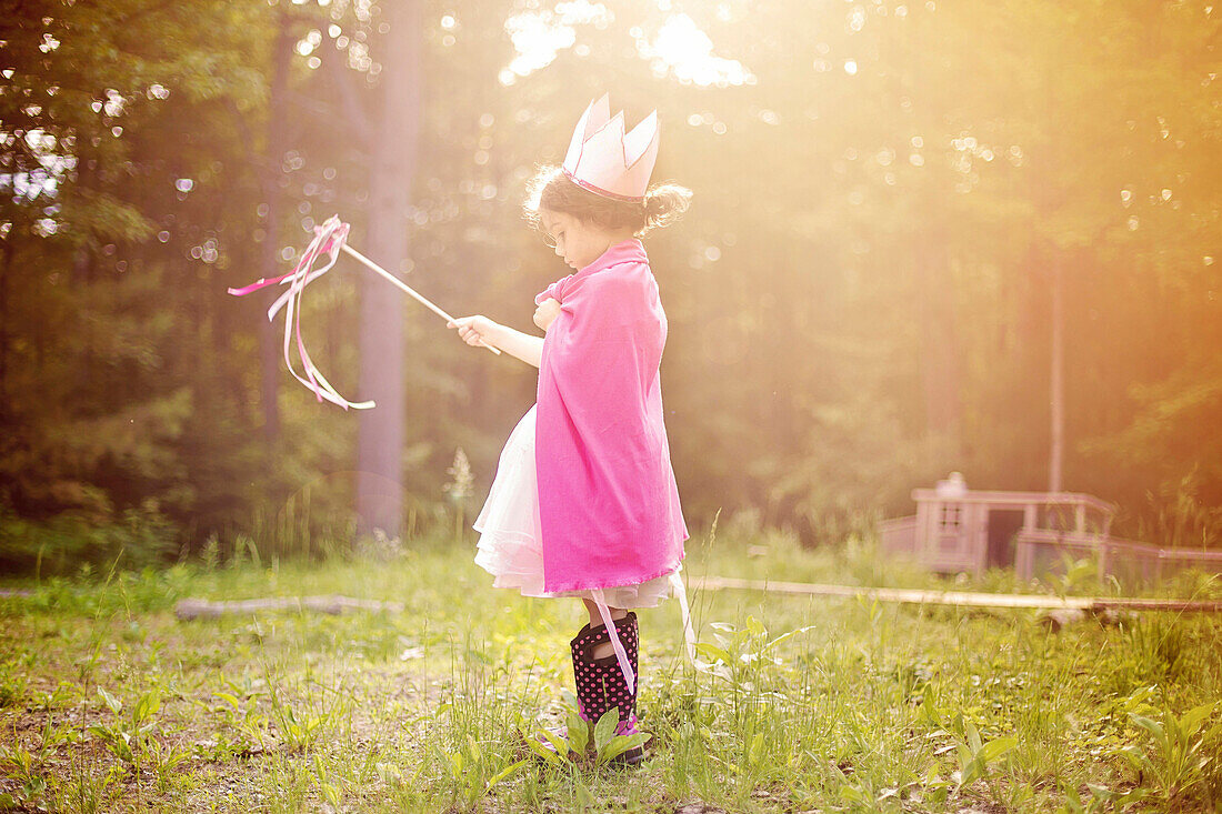 Girl playing princess in backyard