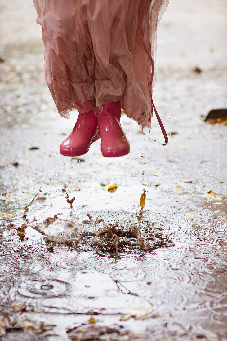 Caucasian girl in rain boots jumping in … – Bild kaufen – 71071133 ...
