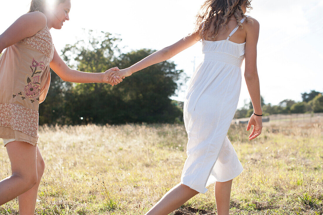 Girls holding hands in field