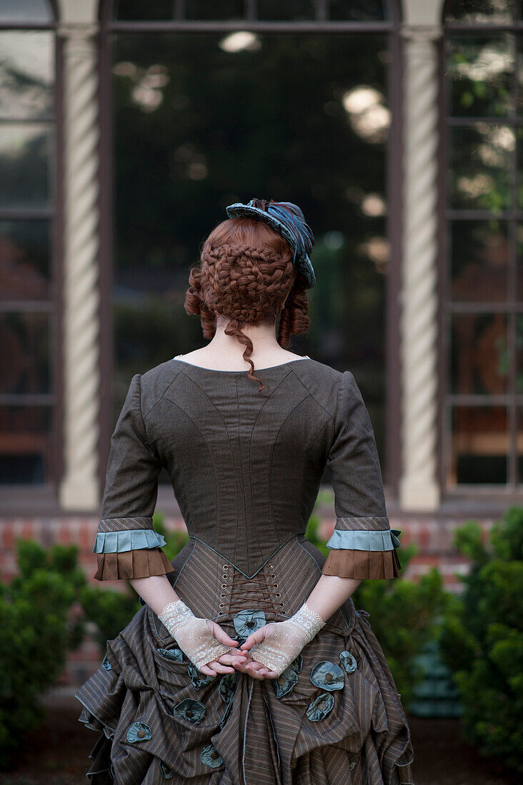 Rear view of woman wearing vintage gown and hat