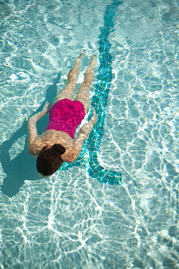High angle view of Caucasian woman swimming in pool
