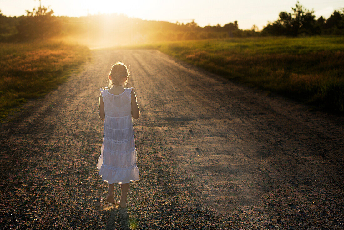 Caucasian girl walking on dirt road