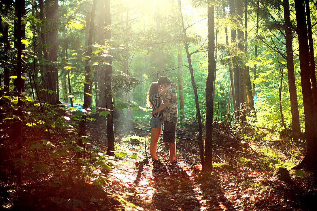 Couple hugging in sunny forest