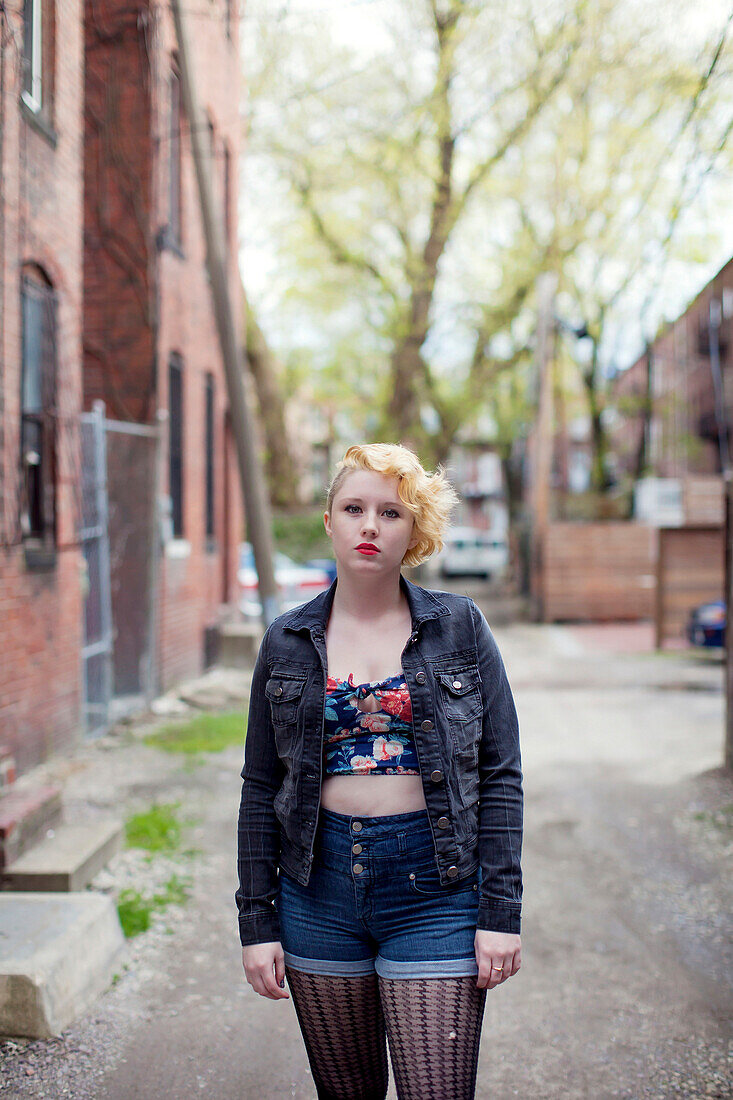 Caucasian teenage girl standing on city sidewalk