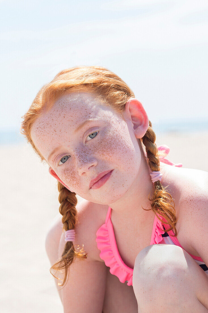 Caucasian girl wearing bathing suit on beach