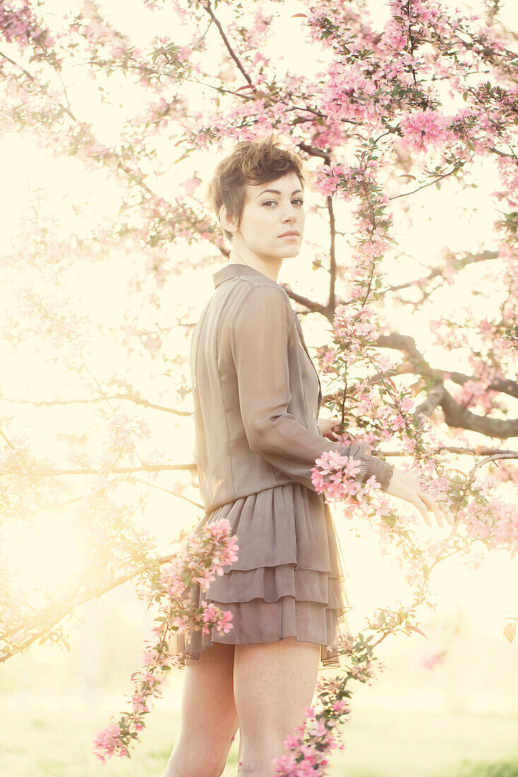 Woman standing in flowering trees