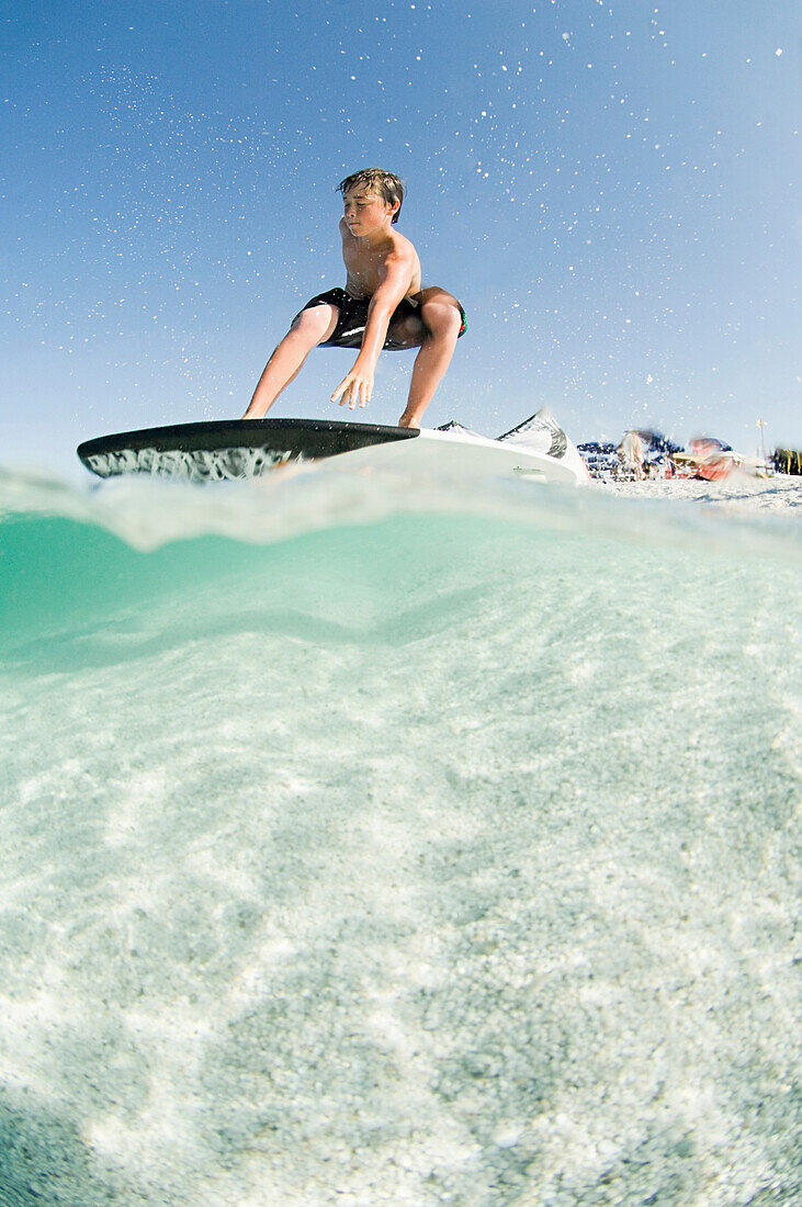 Low angle view of man standing on surfboard