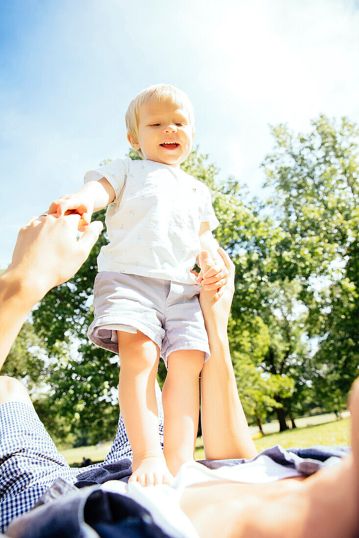 Father and son playing in grass in park