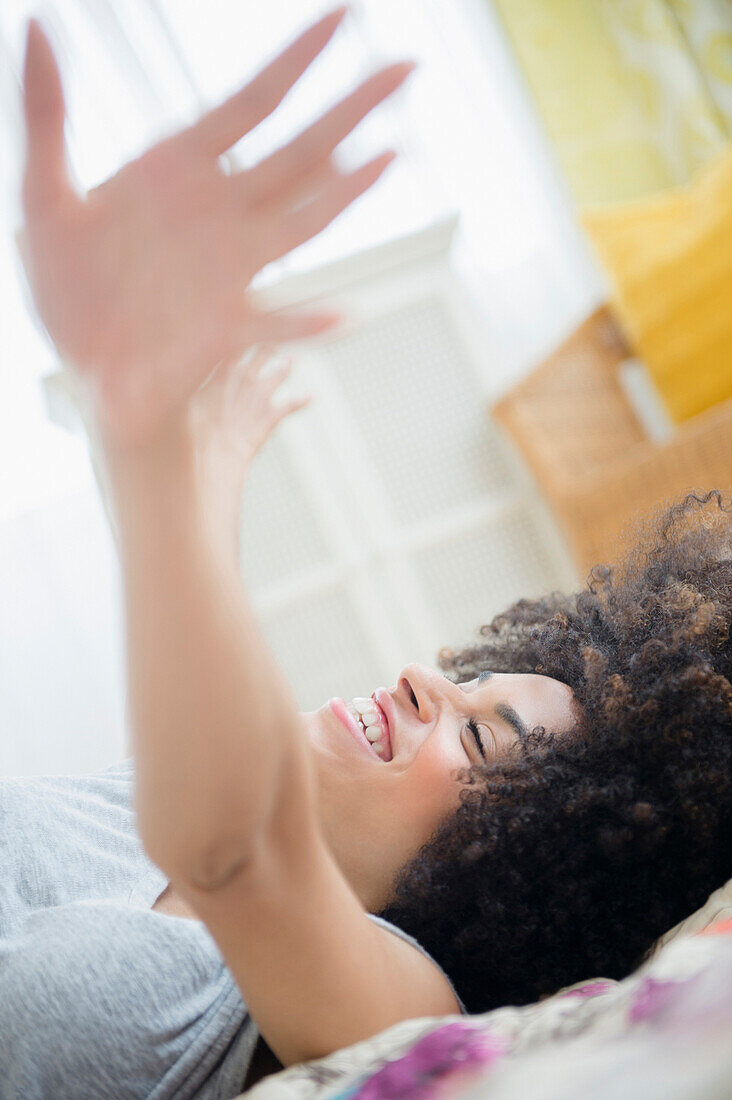 Gemischtrassige Frau auf dem Bett liegend