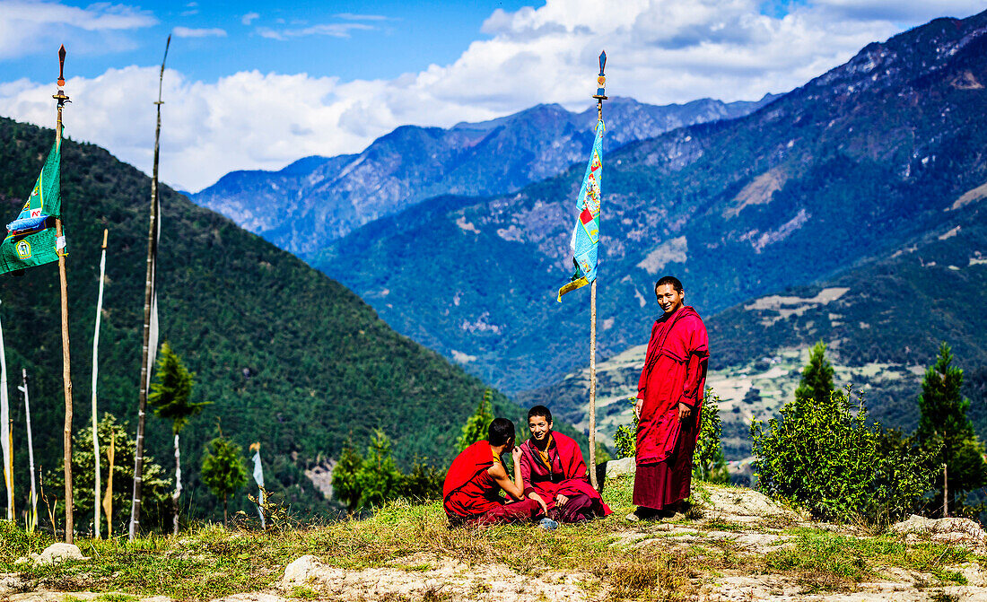 Asian monks with flag on remote hilltop