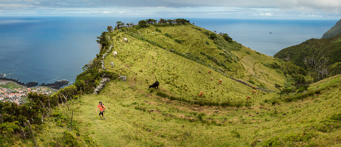 Hiker walking on hilltop path in rural landscape