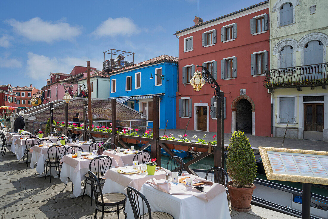 Sidewalk cafe overlooking Venice Burano canal, Veneto, Italy