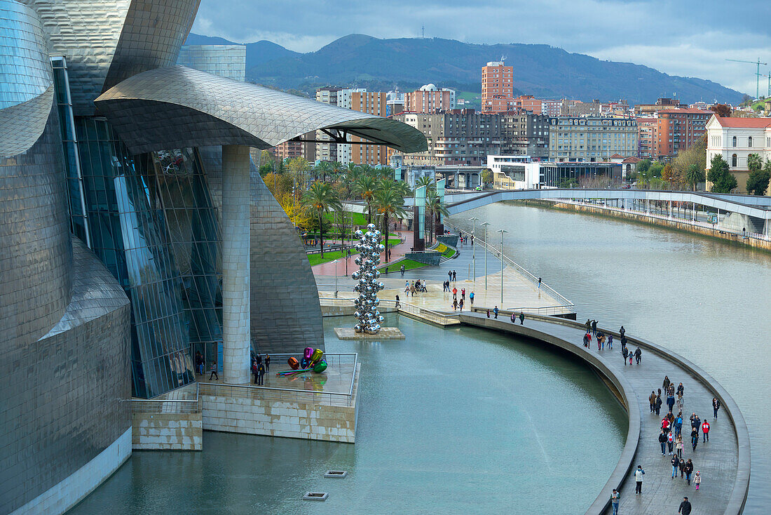 Aerial view of tourists on walkway over urban canal, Bilbao, Biscay, Spain