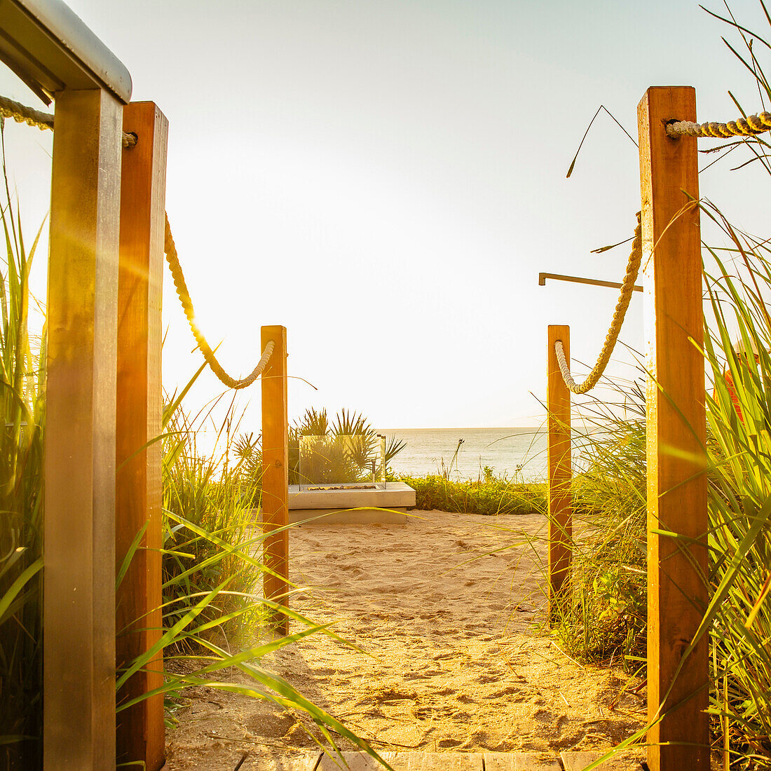 Walkway to beach under blue sky