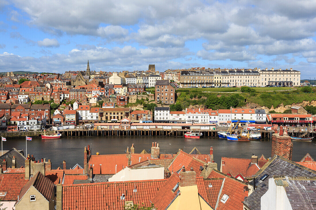 View across rooftops to West Side town, boats, pier, fish market and elegant hotels, Whitby, North Yorkshire, England, United Kingdom, Europe