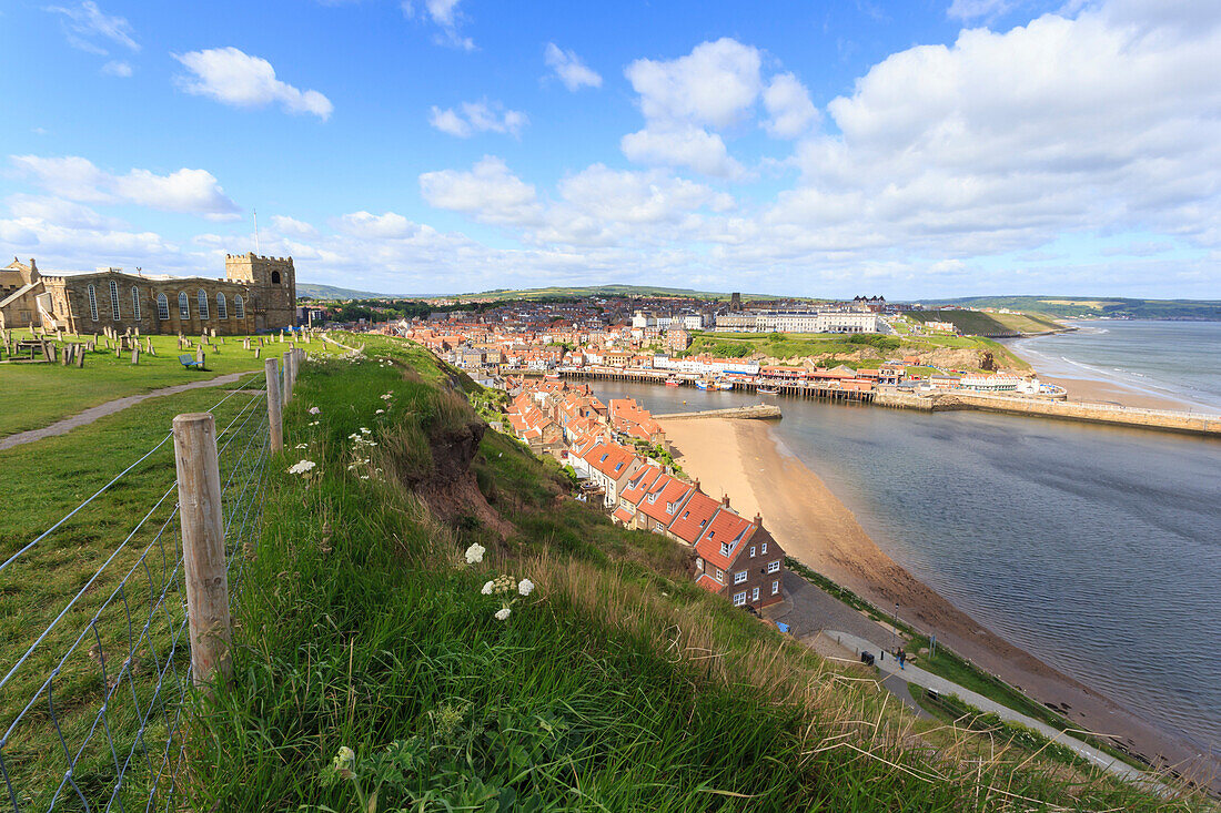 St. Mary's Church and churchyard with view across Tate Hill Beach and town houses to West Cliff, Whitby, North Yorkshire, England, United Kingdom, Europe