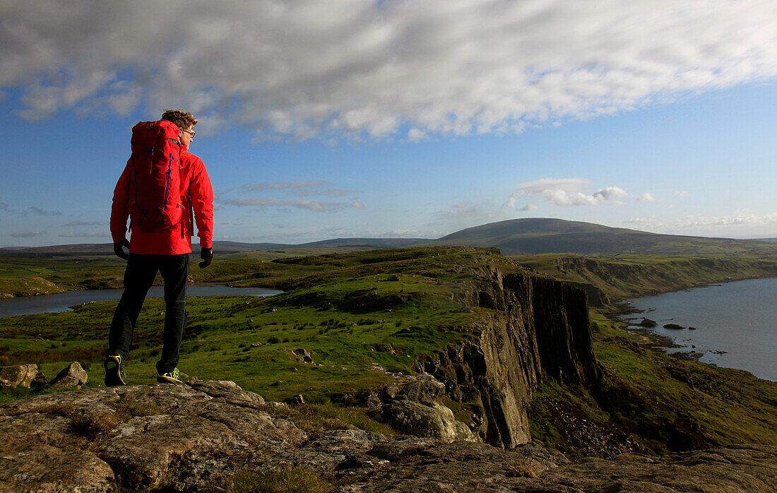 A hiker at Fair Head, County Antrim, Ulster, Northern Ireland, United Kingdom, Europe