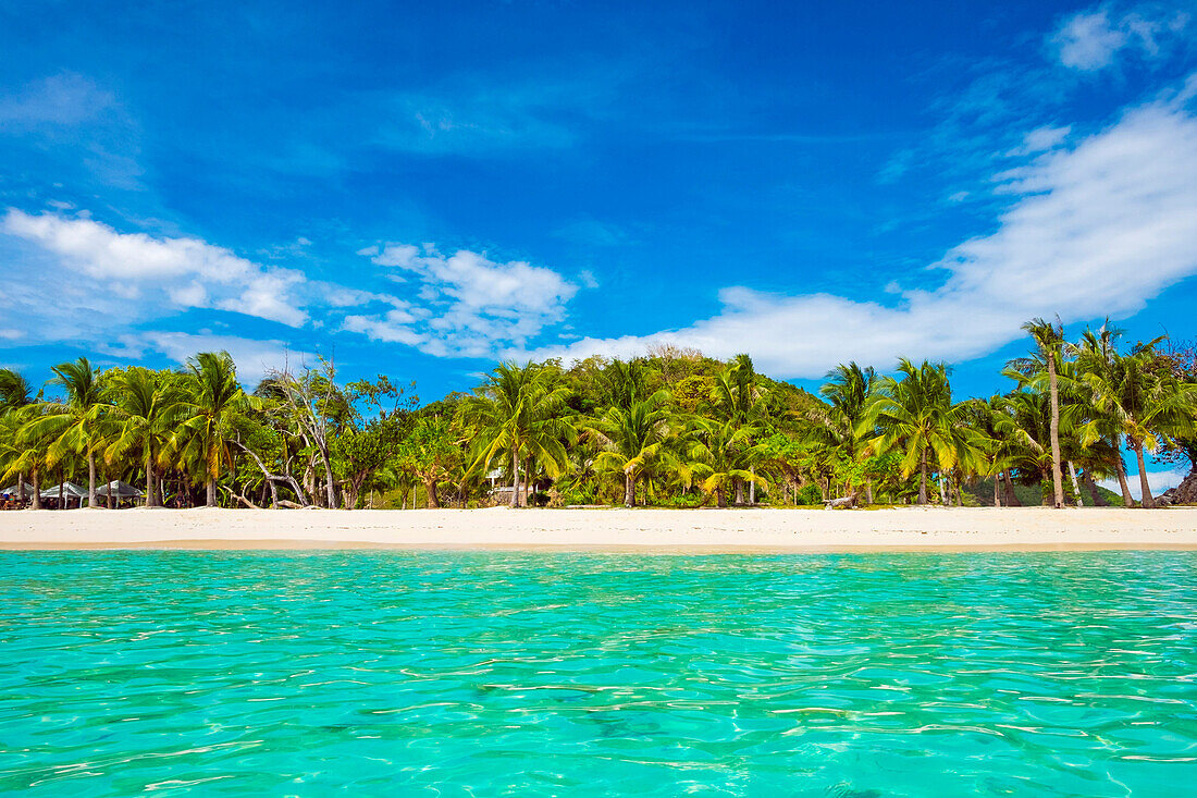 Clear turquoise water and white sand beach at Malcapuya Island