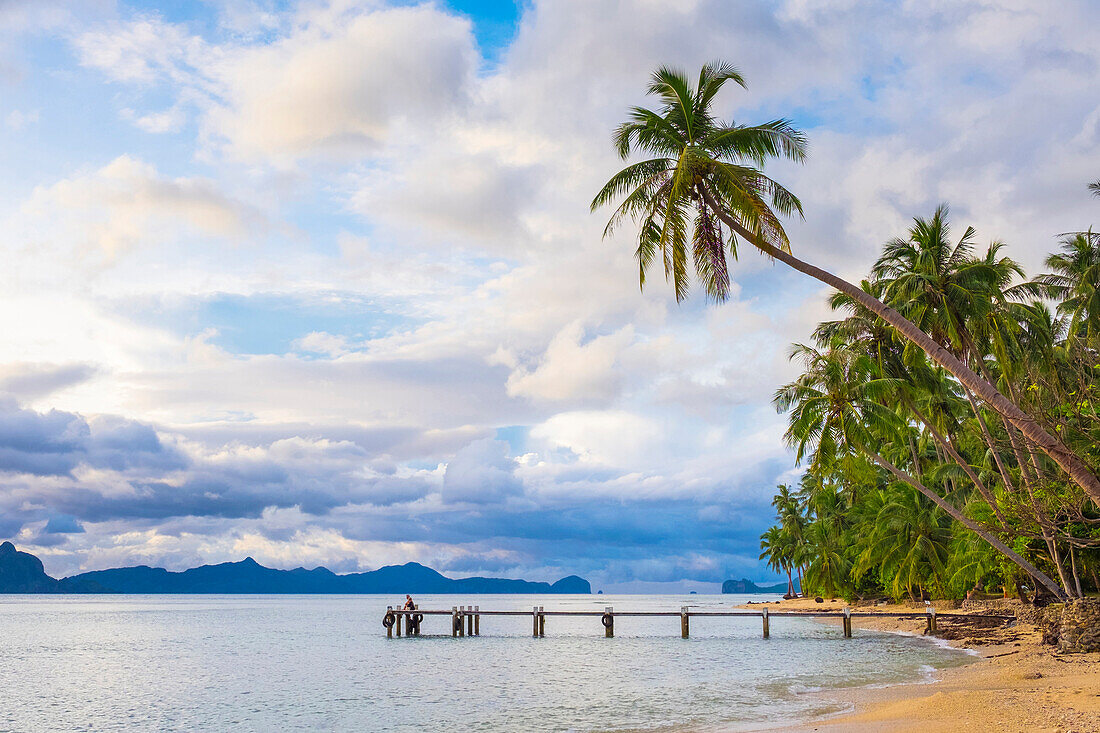 Pier and palmtrees on Dolarog Beach, El Nido, Philippines