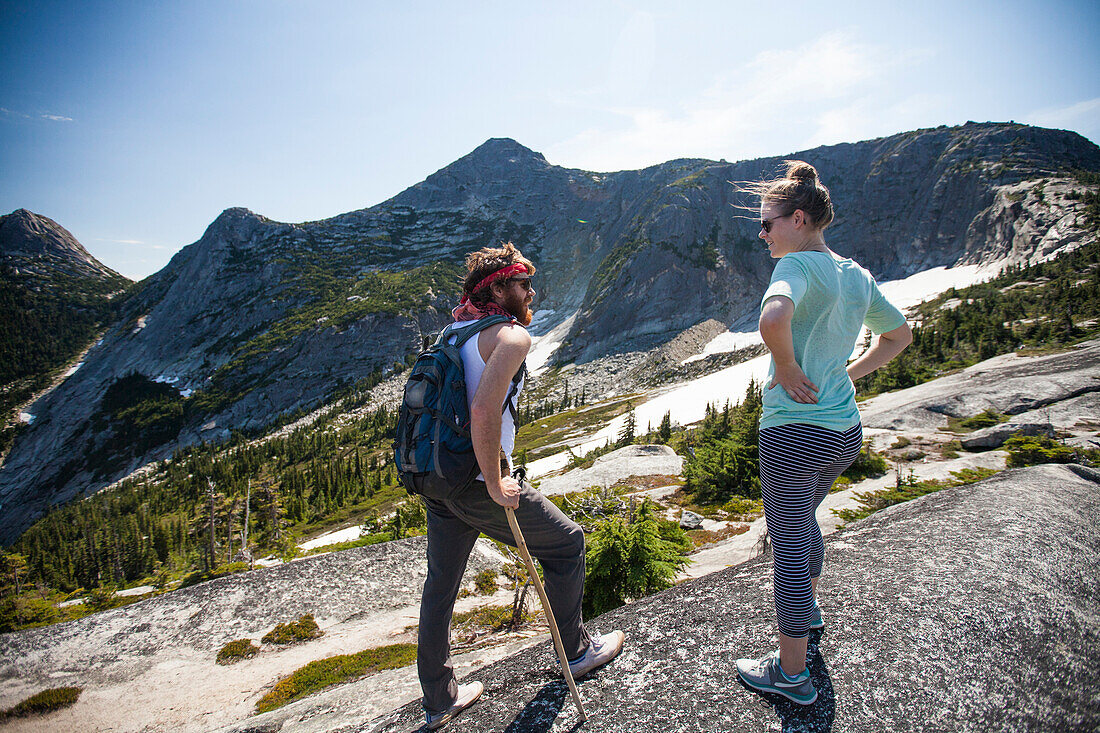 Two backpackers stop to converse while hiking toward Needle Peak, British Columbia, Canada.