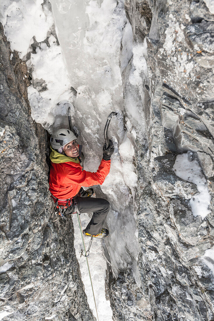 A woman ice climbing a route called  Birdbrain Boulevard on the Camp Bird Road near, Ouray, Colorado.