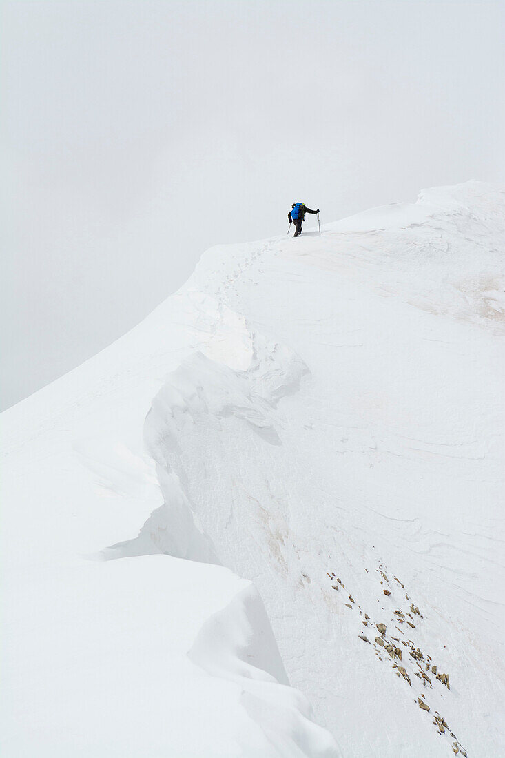 A man  climbing Lizard Head Peak in the Lizard Head Wilderness, Uncompahgre National Forest, Telluride, Colorado.