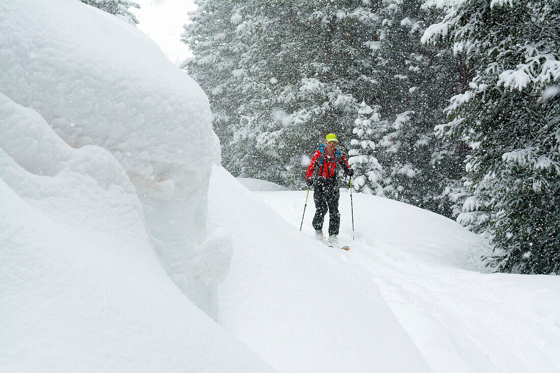 A man backcountry skiing on a snowy day above Red Mountain Pass in the  Uncompahgre National Forest, Silverton, Colorado.