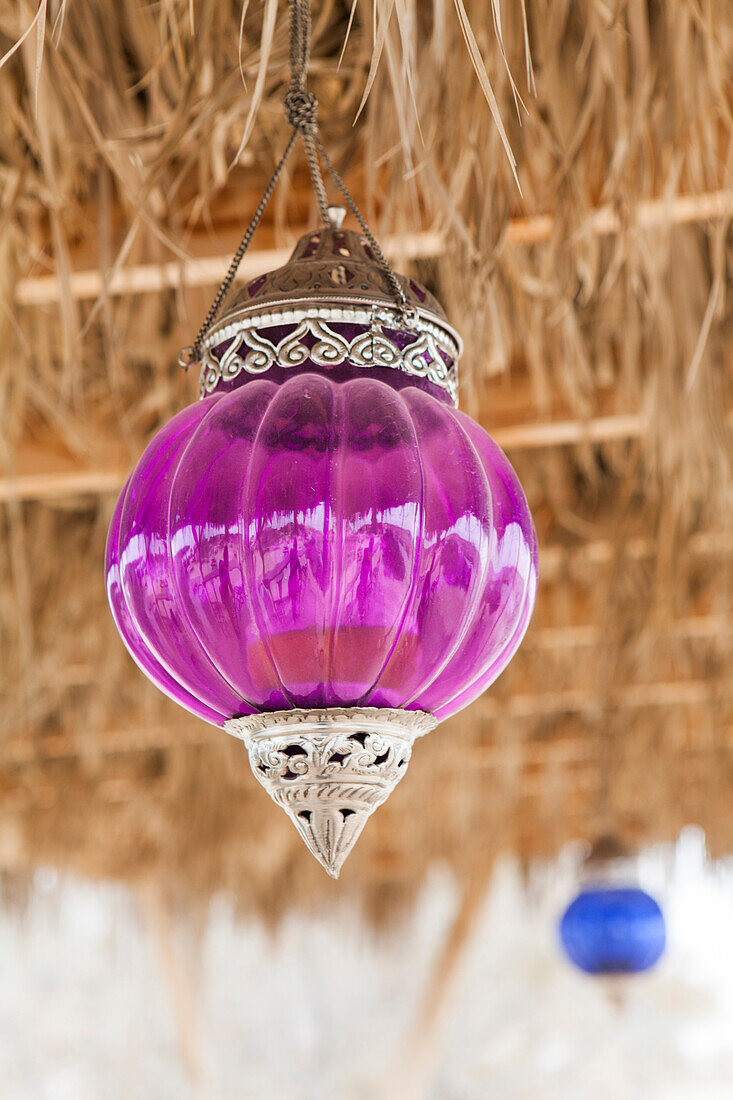 Colorful glass lanterns hang from the thatched roof of Café Ezuz in Ezuz, Israel.